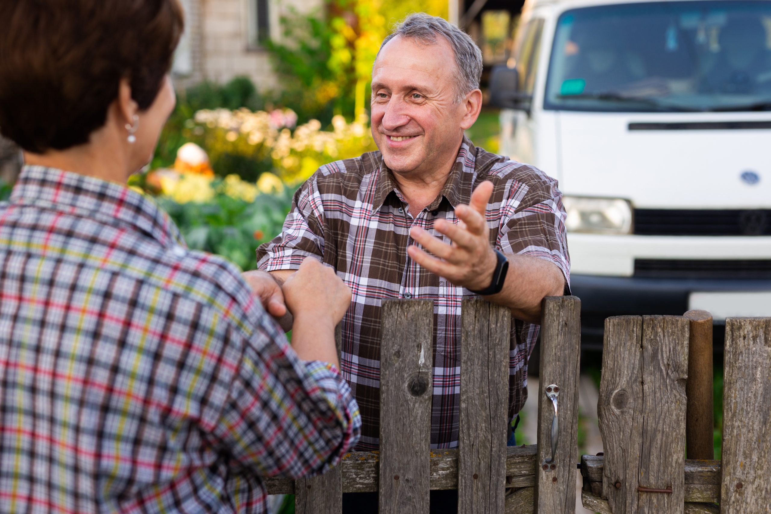 neighbors man and woman chatting near the fence in the village
